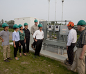 Researchers next to a Photovoltaic farm controller